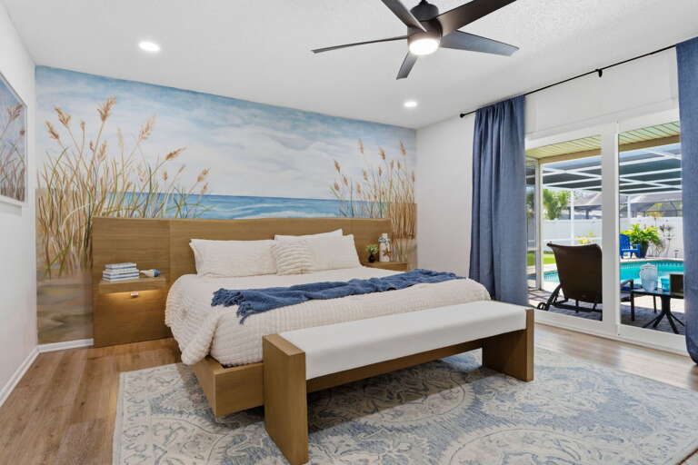 Wake up in the master suite to morning light through sheer curtains — the sliding glass door opens straight to the pool for a sunrise swim.