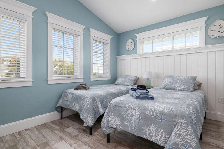 Claim one of the twin beds under the row of transom windows — the starfish bedding does half the work convincing the kids it's bedtime.