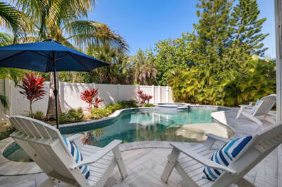Ease into the hot tub while the pool glows just past the umbrella — this fenced-in slice of Florida is yours, and the only company you'll have is palms swaying overhead.