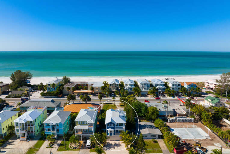 Spot your house from the sky before you ever set foot inside — tucked into the neighborhood, footsteps from where the sand starts.