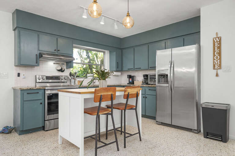 Pull up a stool at the breakfast island for a quick bite before you head out — two seats, good counter, done.