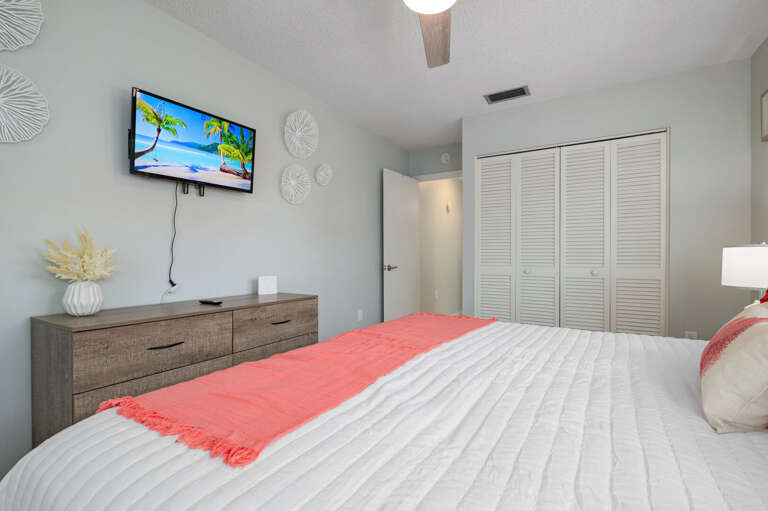 Bedroom three overlooks the pool with a king size bed and a TV