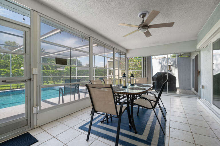 Covered patio, seating for 6, BBQ grill, overlooks the pool, TV and mini fridge.