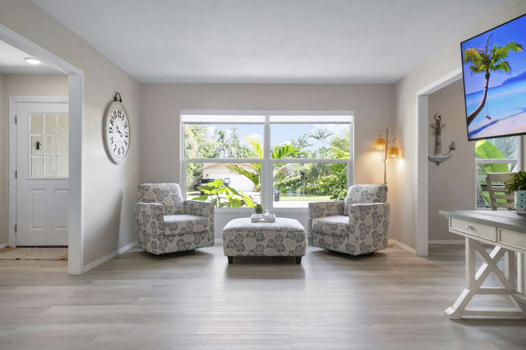 Your quiet corner — two armchairs and an ottoman by the front window, away from the main action. This is where the readers and early risers end up.