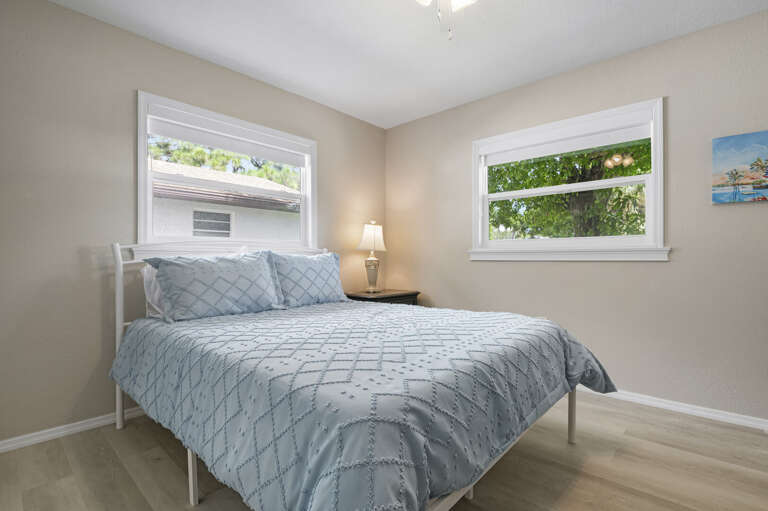 Sleep well here — quiet room, queen bed, morning light through the windows. This is the one guests quietly fight over on the second booking.