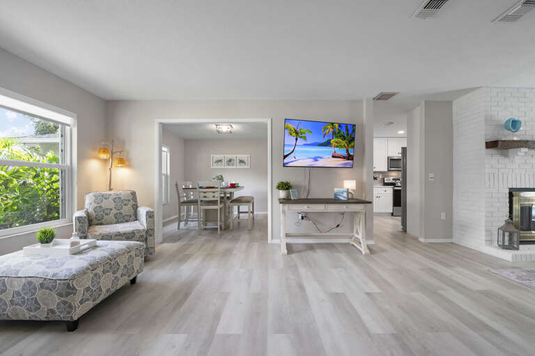 Step into the main living space and see it all at once — dining room ahead, French doors open to the pool.