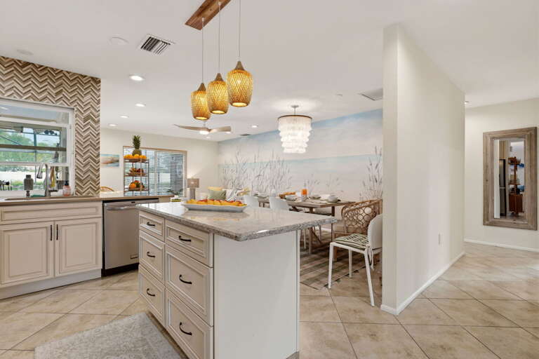 From the kitchen island, you're looking straight at the beach mural — which makes cooking breakfast feel slightly more like vacation.