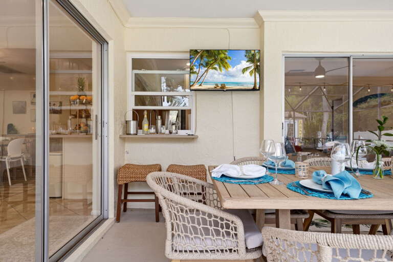 The kitchen pass-through means drinks land in your hand without ever leaving the patio. Your bartender is whoever's closest to the fridge.