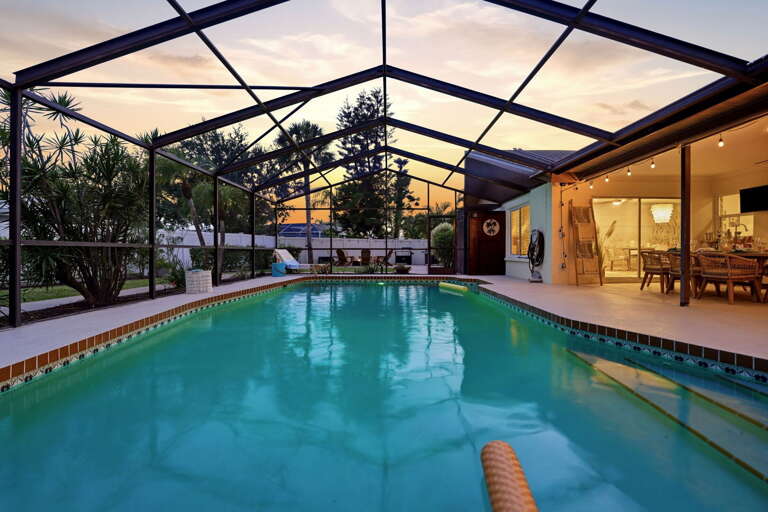 Inside the lanai, pool lit, sky turning. This is the hour that makes everyone reluctant to go back inside.