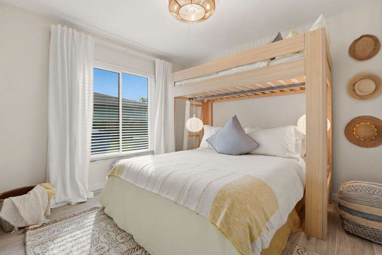Loft over a queen bed, paper lantern pendants lit. The bunk room rests the kids and makes them feel like the trip was made for them.
