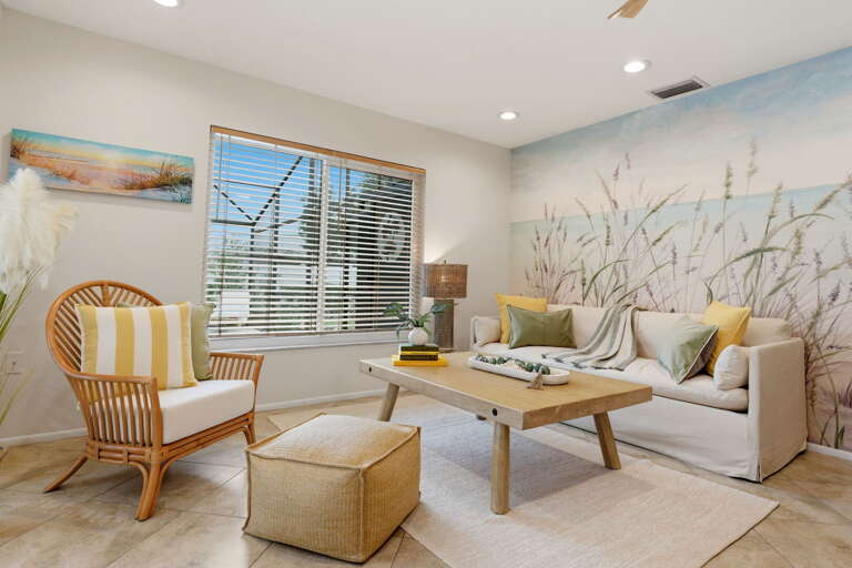 The main living area wraps around the beach mural that anchors the whole space. Settle into the sofa and let the artist's Florida take over.