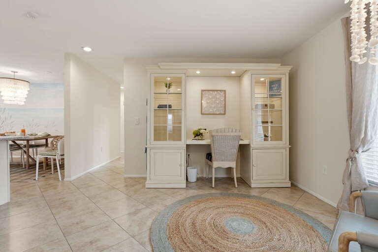 The open floor plan unfolds from the entry — office nook at right, dining room just off, the whole house connected.