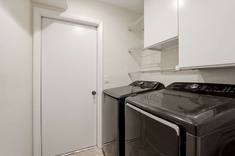 Samsung front-load pair, plenty of cabinet storage. Pack light — the laundry handles the rest of the week.
