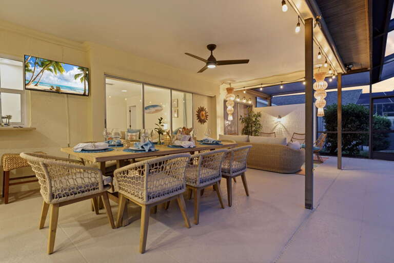 Every string light and pendant on, the outdoor TV glowing, the night just getting started. Pull up a seat — this is where the trip happens.