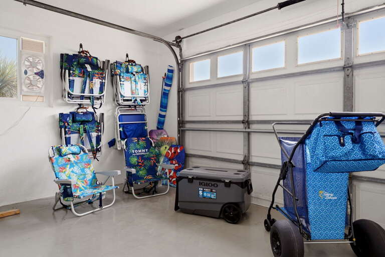 Eight Tommy beach chairs, a wagon, a big cooler — all ready to load up and roll to the beach. You don't pack for this trip, you just go.