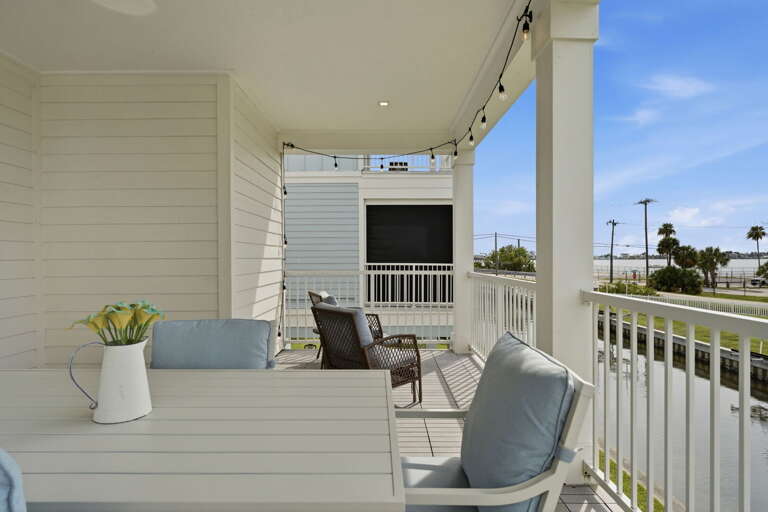 Another angle of the rear deck reveals additional seating, more canal views, and the covered porch that makes this space perfect year-round.