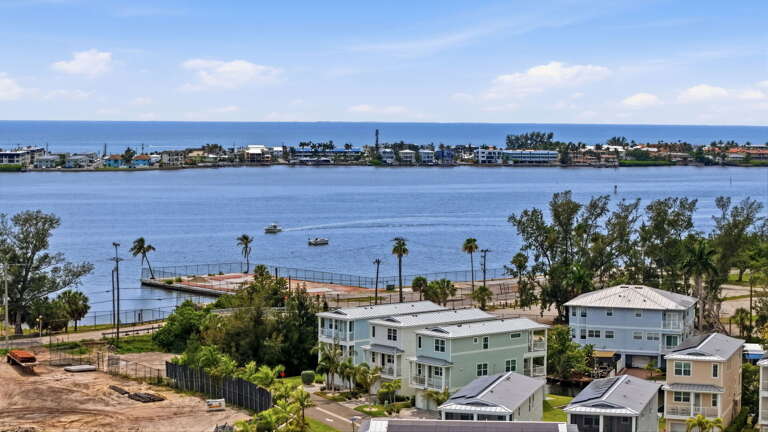 Drone view capturing the full waterway with the property prominently situated along the canal - unbeatable proximity to open water.