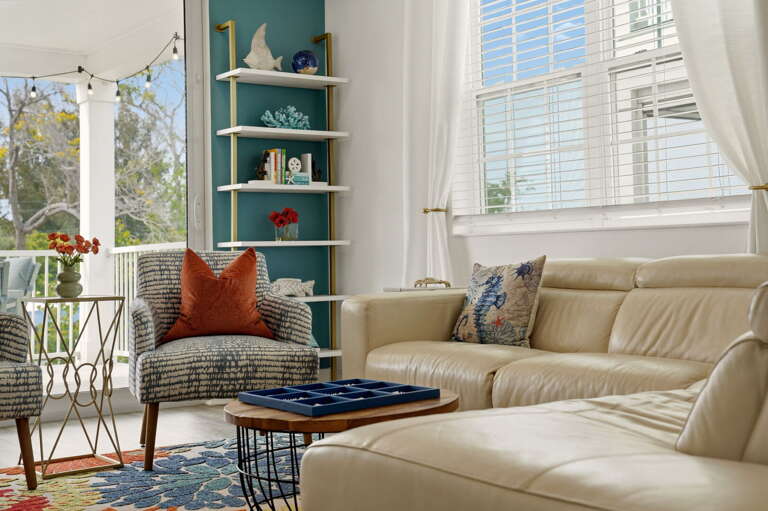 A quiet reading corner in the living room features plush seating, and gorgeous natural light from the floor-to-ceiling windows.