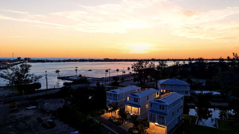 A twilight aerial masterpiece - the property's interior and exterior lights glow in the deep blue of dusk