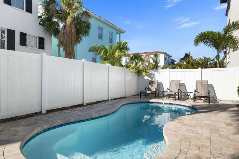 Claim your lounger, order nothing, and let the afternoon stretch around the heated pool — the palms and privacy fence handle the rest for you.