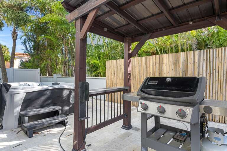 Fire up the grill under the covered pergola while the bamboo fence keeps everything private — the hot tub is right there when dinner wraps up.