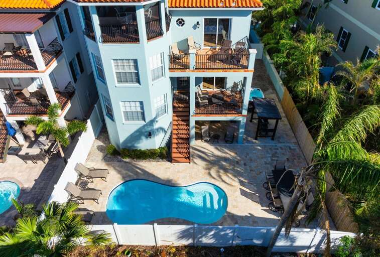 See the full picture from the air — pool, rooftop deck, three levels of balconies. This is what 3,000 square feet of vertical coastal living looks like.