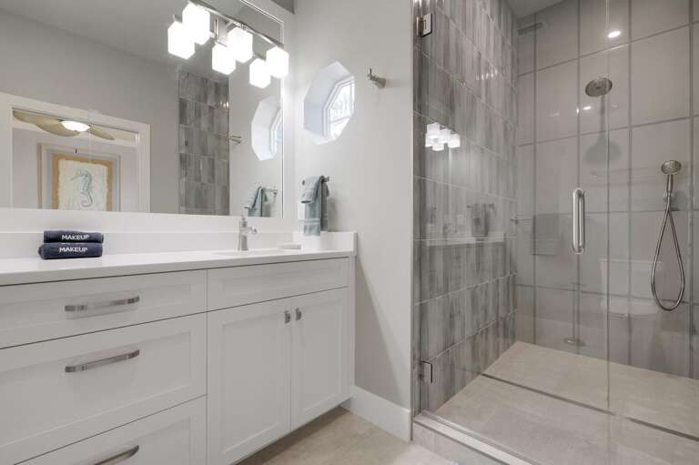 Move slowly through this ensuite — double vanity, glass walk-in shower, grey tile accent wall. You'll find yourself taking longer showers than you planned.