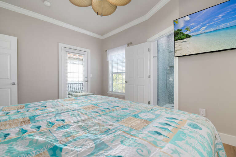 Your queen bedroom alternate angle shows the glass shower through the open bathroom door — every bedroom in this house has its own full ensuite bath.