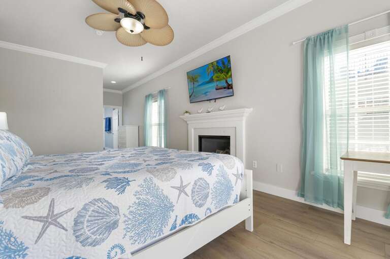 Your starfish quilt, white fireplace, teal shelving, and wall TV make this king bedroom worth retreating to long before you're tired. It's a legitimate excuse to disappear.