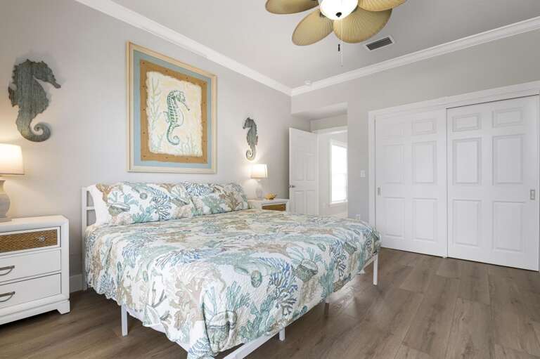 Wake up to ocean-print bedding, seahorse wall art, and a double closet built for a real stay — this king bedroom was styled for people who actually want to be here.