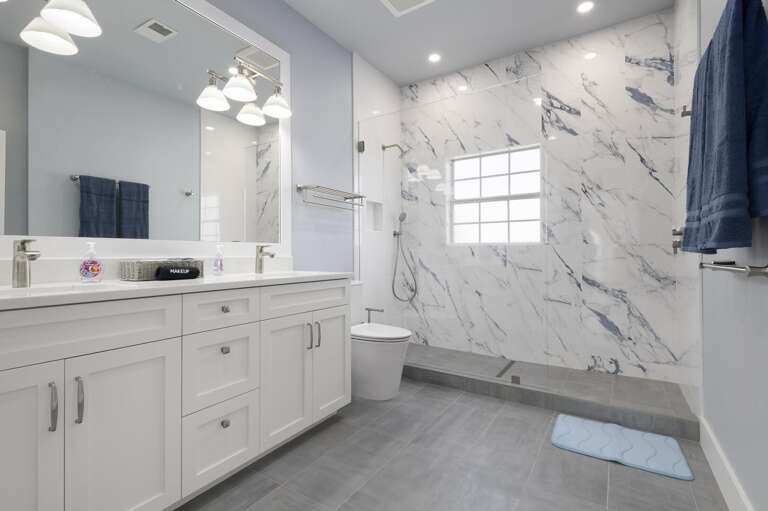 Your walk-in shower has floor-to-ceiling white marble and enough room to share — the double vanity has real counter space. This bathroom is worth taking your time in.