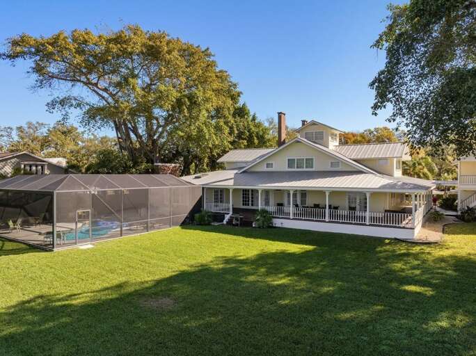 Big lawn, screened-in pool, room to roam. The whole property, one frame.