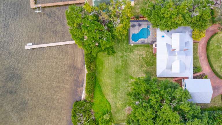 Get the bird's-eye version of your stay — waterfront yard, pool, and dock laid out below like a map of everything you get to enjoy.