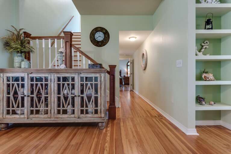 Head down the hallway toward the half bath and master suite — everything downstairs stays just a few steps apart.