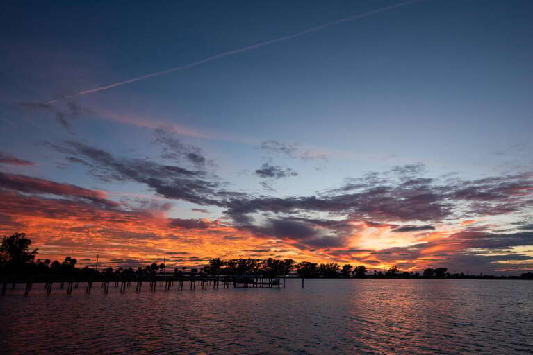 Step onto the porch as the color changes over the water — most nights, this is where the whole trip slows down. Sunset view from the house