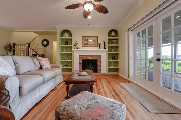 Trade the porch for the couch once it cools off and let the double doors stay open to the bay breeze.
