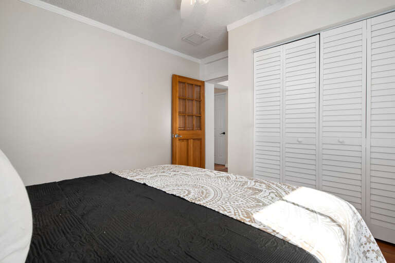 Close the louvered doors, pull the dark bedding up, and disappear for a while. Quiet, private, and exactly what a vacation bedroom should be.