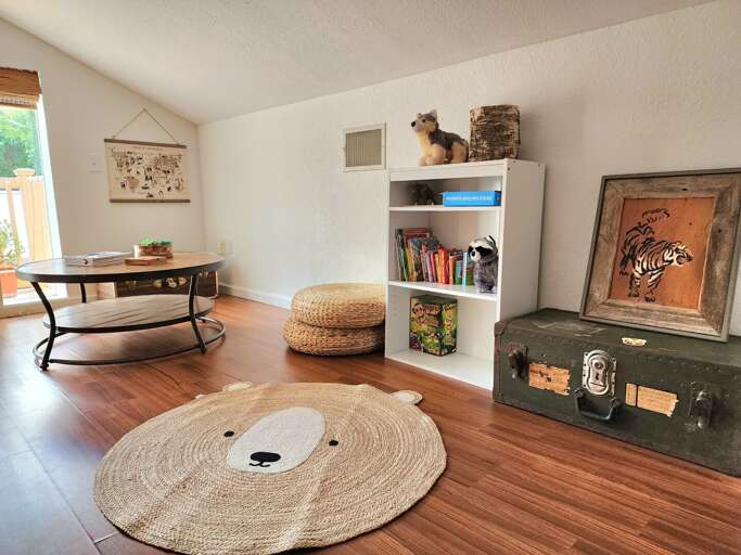 Pack the kids off to the loft play area — bear rug, stuffed animals on the shelf, vintage trunk to sit on — and take back an actual quiet hour downstairs.