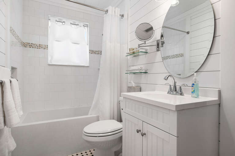 Rinse off after the pool in a bathroom that kept its old-Florida soul: shiplap walls, pedestal vanity, tub-shower combo. Updated without losing any of the original character.