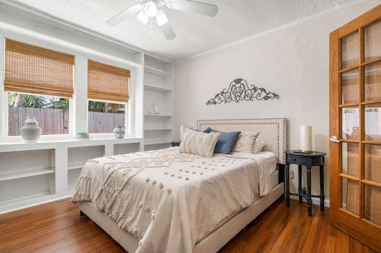 Sleep on an upholstered headboard with a white duvet and built-in shelving for books and chargers within arm's reach. The bedroom you didn't expect to love this much.