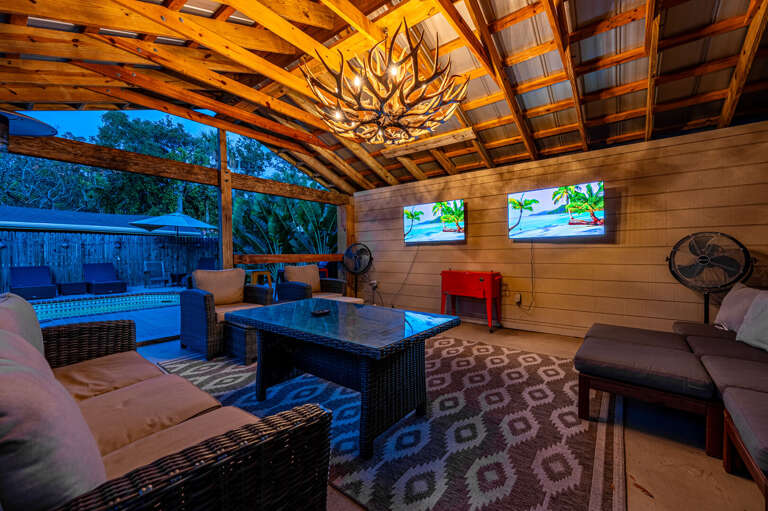 Step outside into the cabana and find two 50-inch TVs, wicker lounge seating, and open air on every side. Game day or movie night, the outdoor living room handles it.
