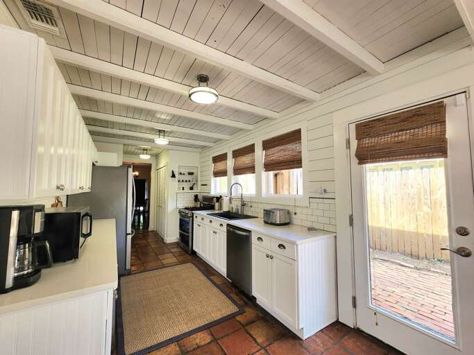 Walk the full length of the kitchen — from one end to the other and out the back door to the pool deck. Prep at one side, cook on the other.