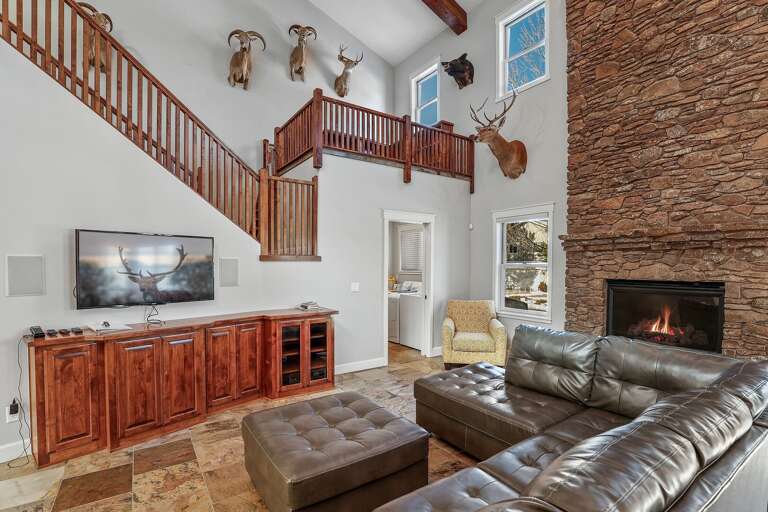 The heart of the home is a grand living area, boasting soaring A-frame ceilings and a dramatic floor-to-ceiling stone fireplace, perfect for gathering around on cool Flagstaff evenings. The heart of the home is a grand living area, boasting soaring A-frame ceilings and a dramatic floor-to-ceiling stone fireplace, perfect for gathering around on cool Flagstaff evenings.