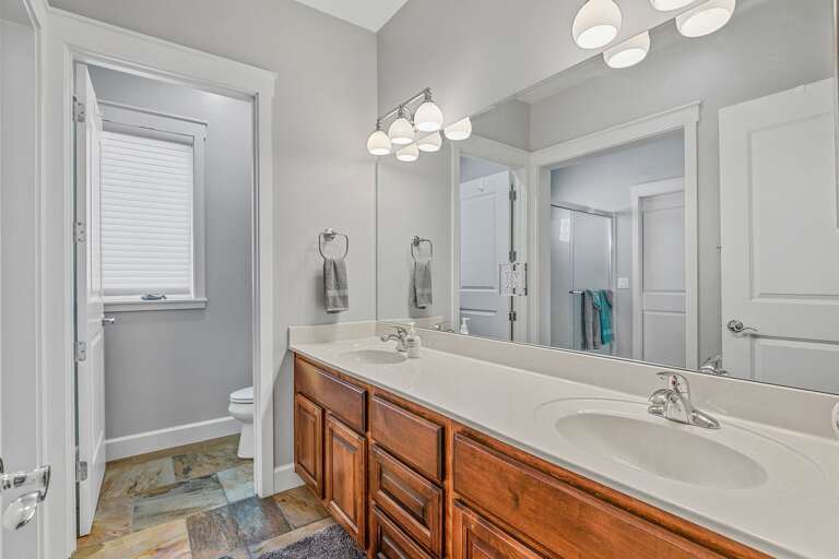 Primary en-suite bathroom on the 1st Floor with a whirlpool spa, walk-in shower, double vanities, and a separate commode room. Primary en-suite bathroom on the 1st Floor with a whirlpool spa, walk-in shower, double vanities, and a separate commode room.
