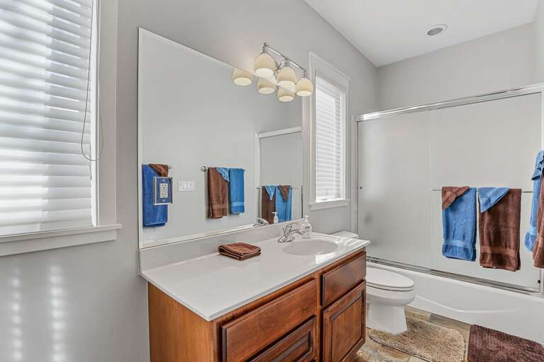 Smaller Master Bedroom - 1st Floor: En-suite bathroom featuring a vanity, shower/bathtub combo, and mirrored closet doors. Smaller Master Bedroom - 1st Floor: En-suite bathroom featuring a vanity, shower/bathtub combo, and mirrored closet doors.