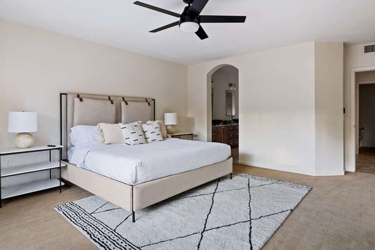 Master bedroom with arched entryway to the en-suite bathroom.