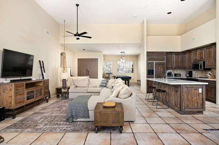 Bartop seating at the kitchen island. A large sectional is in the living room. Bartop seating at the kitchen island. A large sectional is in the living room.