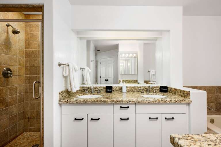 Double sinks set with a walk-in shower to the left and a tub to the right. Double sinks set with a walk-in shower to the left and a tub to the right.