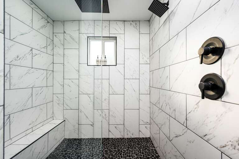 Master en-suite bathroom with double sinks and waterfall showers.