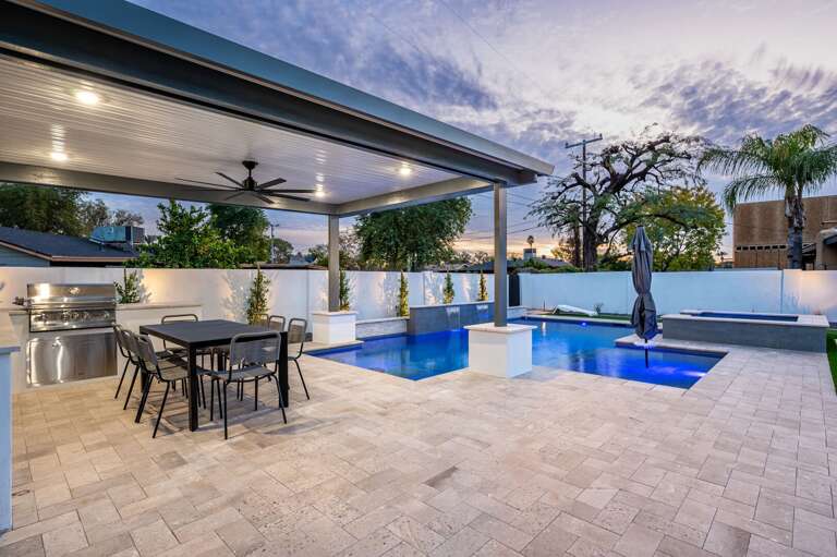 Outdoor dining for 6 people next to the bbq under a ceiling fan.